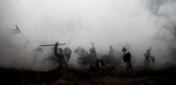 istock Medieval battle scene with cavalry and infantry. Silhouettes of figures as separate objects, fight between warriors on sunset foggy background. 1133071709