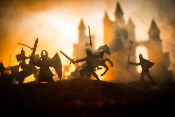 istock Medieval battle scene with cavalry and infantry. Silhouettes of figures as separate objects, fight between warriors on sunset foggy background. 1133071712