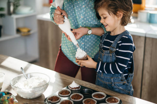 istock Decorating muffins with baby boy son 1133074269