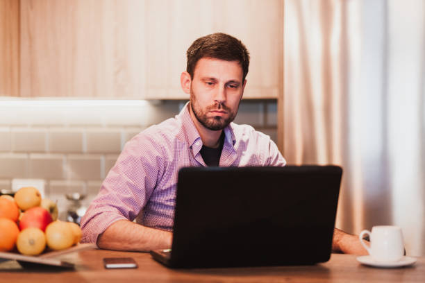 istock Young businessman working on a laptop at home 1133076027