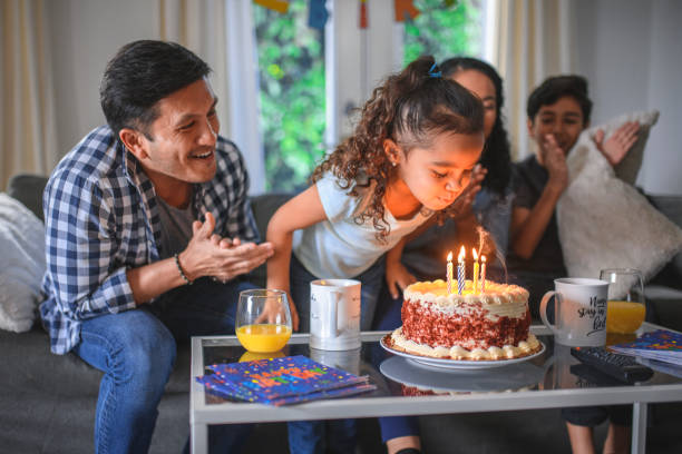 ragazza che festeggia il compleanno con la famiglia a casa - birthday family party cake foto e immagini stock