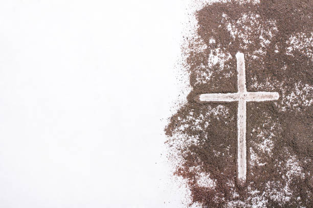 Cross and ash on white background - symbol of Ash Wednesday. Copy space