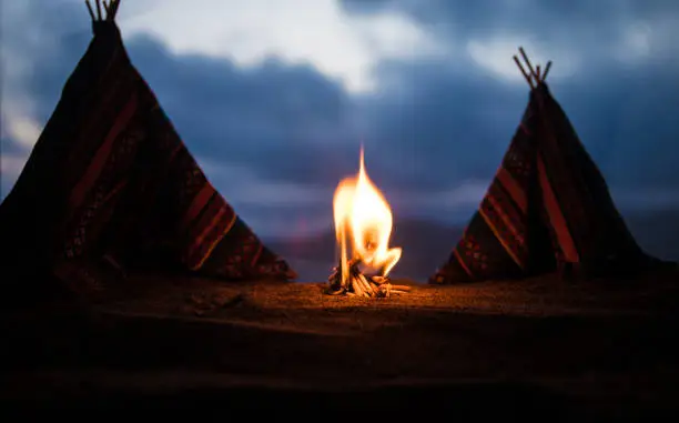Artwork decoration creative concept. An old native american teepee in desert at the evening. Wigwam house indian style.