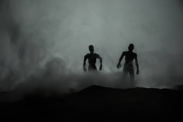 istock Silhouette some zombies on the cemetery walking around at sunset. Selective focus 1133088178
