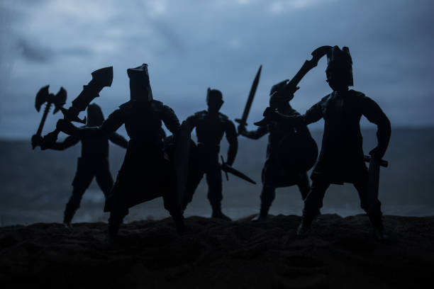 istock Medieval battle scene with cavalry and infantry. Silhouettes of figures as separate objects, fight between warriors on sunset foggy background. Artwork decoration. Selective focus 1133088254
