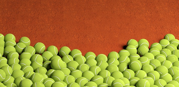 lots of tennis balls on clay