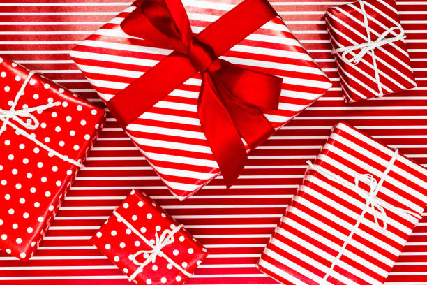 istock Various size wrapped in red paper with ornament Christmas gift boxes on red with white lines background 1133111754
