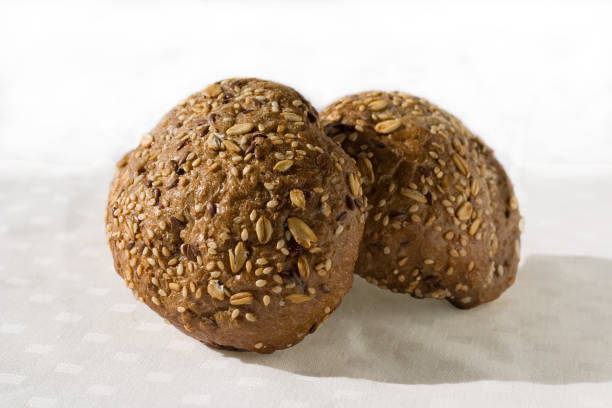 istock Twee round dark colored buns with varios seeds on a light background. Close up 1133116880
