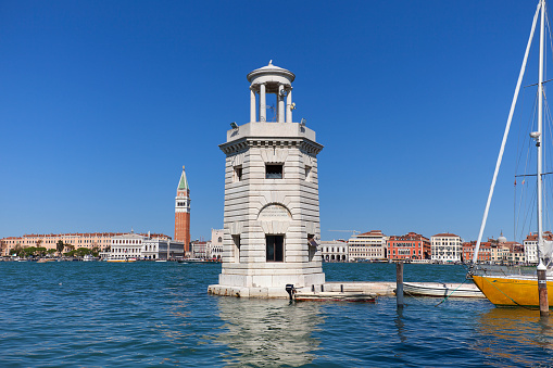 Venice, Italy - September 21, 2017: Lighthouse on San Giorgio Maggiore and view on tower St Mark's Campanile. San Giorgio Maggiore is a small island of lagoon of Venice, north of the Adriatic Sea.