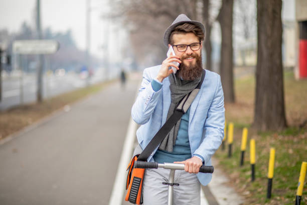 istock Young businessman with a beard smiling on kick scooter 1133121446