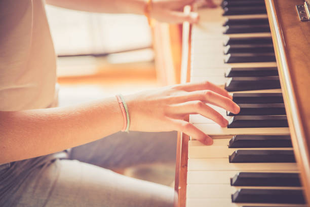 istock Girl is playing piano at home, high angle view, blurry background. 1133123484