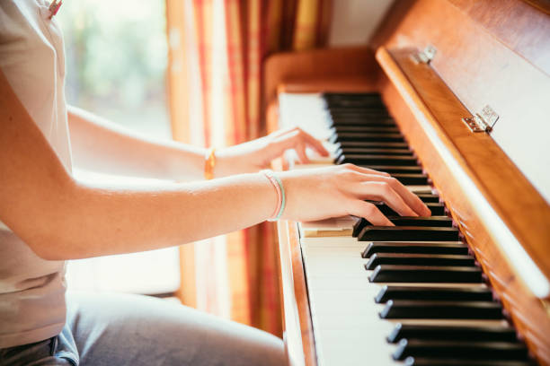 istock Girl is playing piano at home, high angle view, blurry background. 1133123486