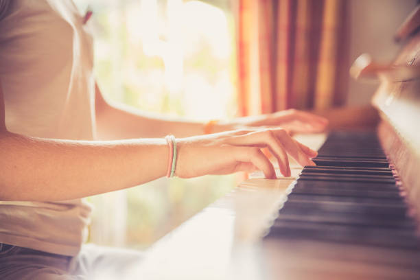 istock Girl is playing piano at home, high angle view, blurry background. 1133123499