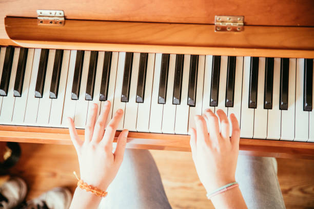 istock Girl is playing piano at home, high angle view, blurry background. 1133123527