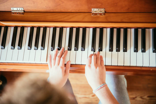 istock Girl is playing piano at home, high angle view, blurry background. 1133123534