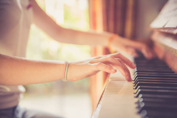 istock Girl is playing piano at home, high angle view, blurry background. 1133123566