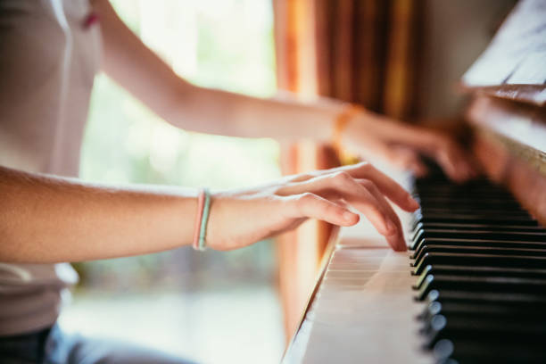 istock Girl is playing piano at home, high angle view, blurry background. 1133123578