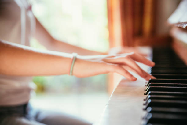istock Girl is playing piano at home, high angle view, blurry background. 1133123586