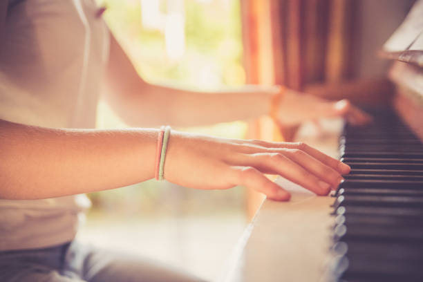 istock Girl is playing piano at home, high angle view, blurry background. 1133123587