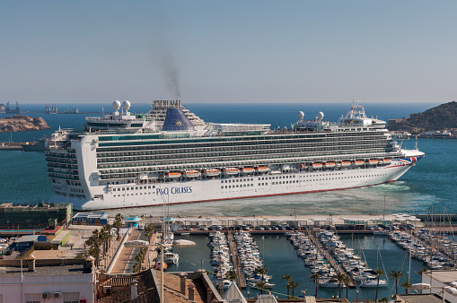 15th June, 2022.  Cunard's imposing cruise ship 'The Queen Victoria' moored up alongside small sailing boats in the harbour port of Cartagena in Spain