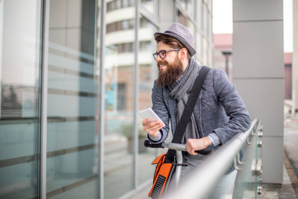 istock Young businessman with a beard smiling on kick scooter 1133124967