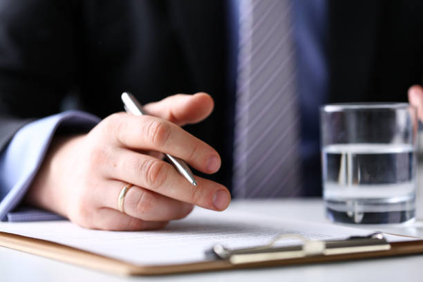 istock Arm fill and sign important form clipped to pad with silver pen 1133125585