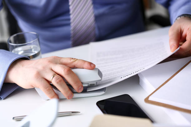 istock Male clerk arm pin together some papers with stapler 1133125587