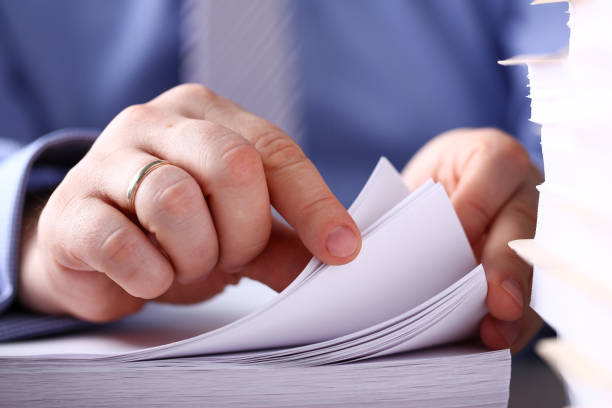 istock Clerk arm bend over pages in pile of documents closeup 1133125589