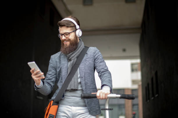 istock Young businessman with a beard smiling on kick scooter 1133125624