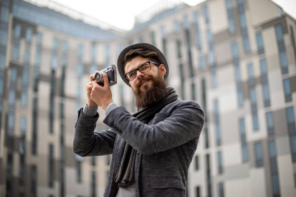 Young hispanic man using vintage camera at park