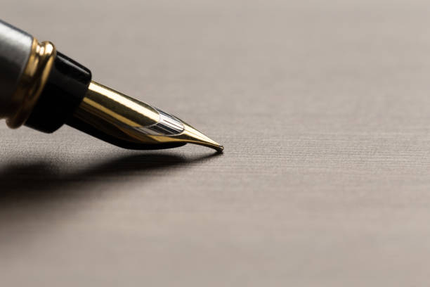 istock fountain pen on wooden table 1133127897