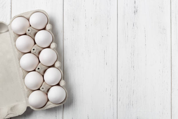 istock Opened cardboard box of eggs on wooden table with copy space 1133129213