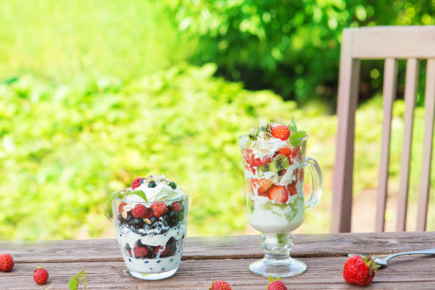 istock Layered dessert with raspberry, strawberry, black currant and kiwi, cream and biscuits in glasses 1133130554