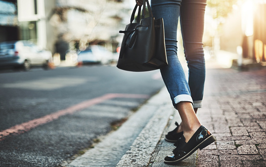 Closeup shot of a businesswoman walking with her handbag in the city