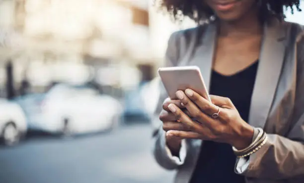 Closeup shot of a businesswoman using a cellphone in the city