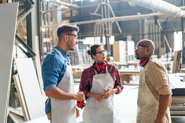 istock Carpenters discussing while working in factory 1133142409