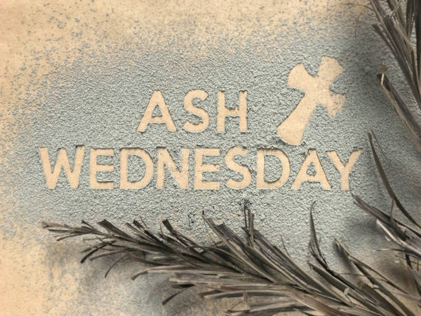 Ash Wednesday concept. Ash Wednesday words and a cross formed out of ashes. There are dry palm leaves on the sides. worshipper photos stock pictures, royalty-free photos & images