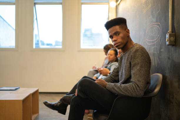 groupe de personnes attendant une entrevue d'emploi - unemployment waiting in line waiting room interview photos et images de collection