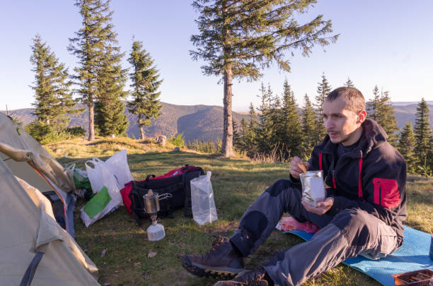 istock A man has lunch in the mountains. Cooking in a hike. 1133152195