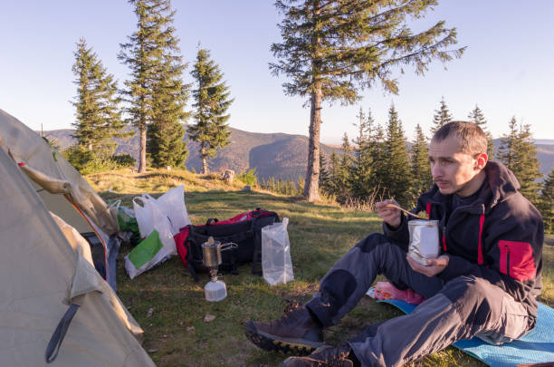 istock The guy has breakfast in the mountains. A man eats in nature. 1133152208