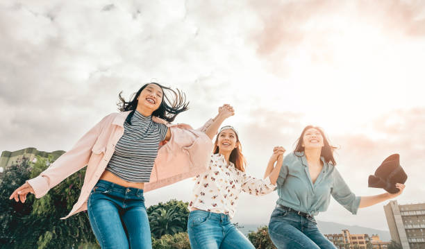 ハッピーアジアの女の子跳躍屋外-若い女性の友人は大学の休憩の間に楽しみを持っている-ミレニアル世代、友情と若者の人々のライフスタイル - teenager child student social gathering ストックフォトと画像