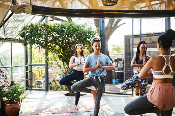 istock Multi-ethnic females practicing tree pose on porch 1133154420