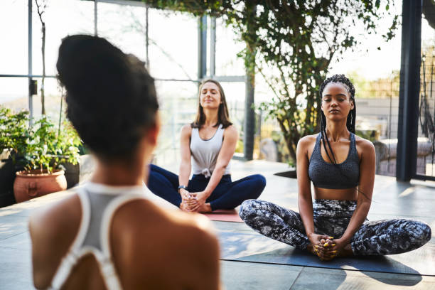 istock Women meditating with instructor during yoga class 1133154428