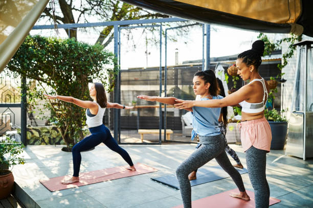 istock Instructor teaching Warrior Pose to female athlete 1133155091
