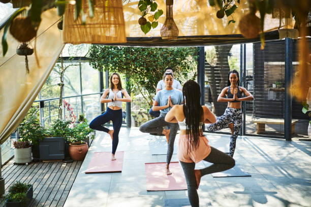 istock Mid adult instructor teaching tree pose to people 1133155228