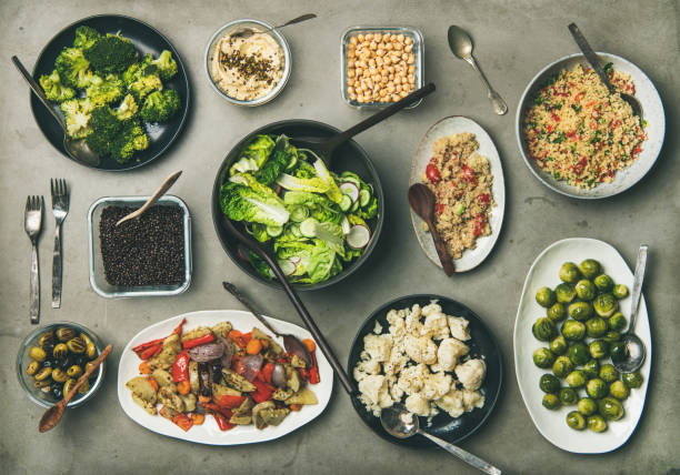 istock Healthy vegetarian dishes in plates ans bowls on concrete table 1133157199