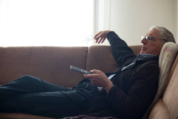 istock Senior Man Relaxing on Couch and Watching TV 1133157417