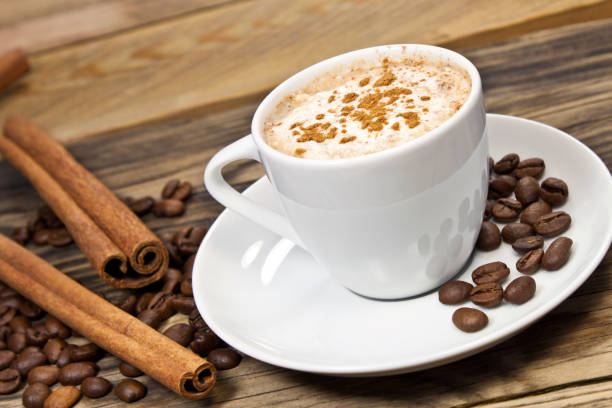istock Coffee cup with cinnamon and beans against wooden background 1133158989