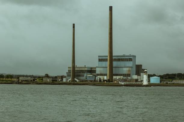 Factory Factory with industrial chimneys and lake with mooring. ingenieur stock pictures, royalty-free photos & images