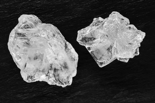 istock Top view of two sugar or salt crystals placed on black stone background surface 1133160630